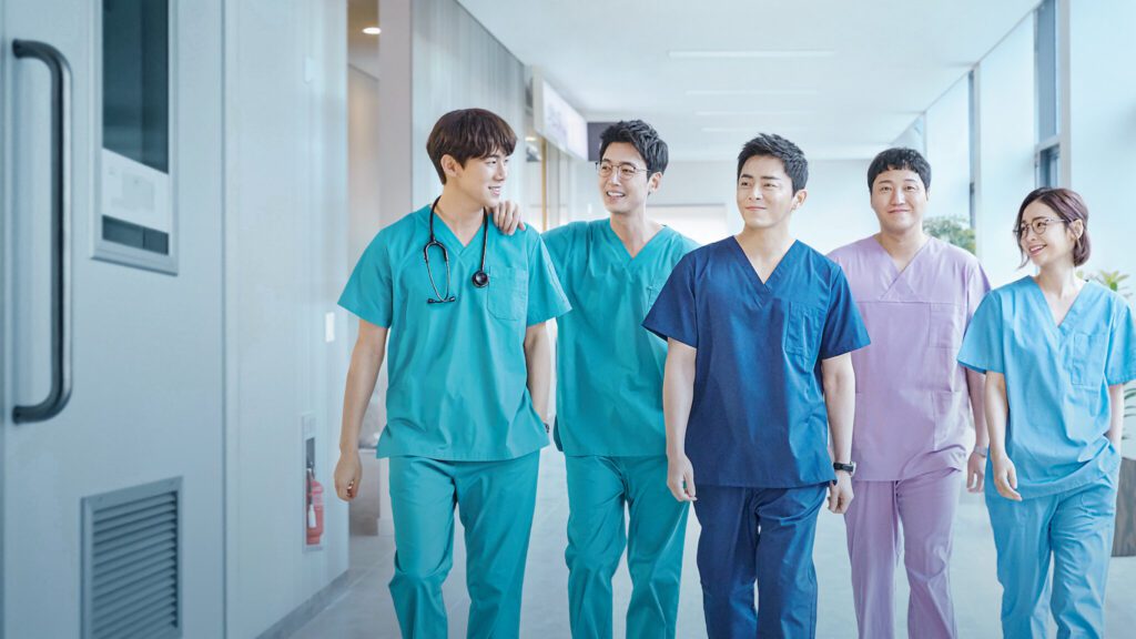 Hospital Playlist Korean drama doctors walking together in hospital corridor wearing medical scrubs